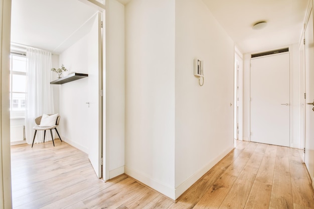 Porta di un appartamento moderno con pareti bianche e pavimento in parquet