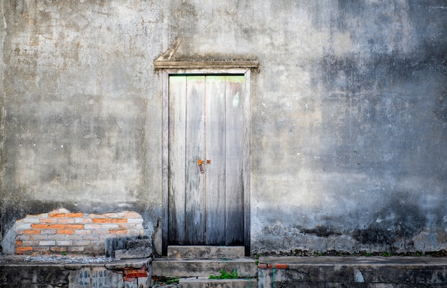 Porta e muro di cemento scuro vecchio look retrò in Thailandia, calcestruzzo adatto per l'assemblaggio o l'uso di uno spazio di copia Idea