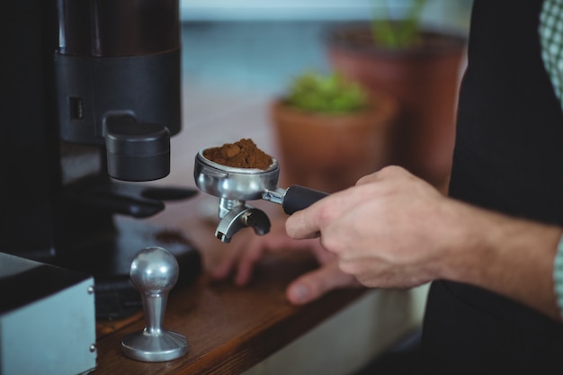 Portafiltro con cameriere pieno di caffè macinato