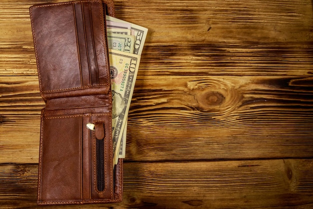 Portafoglio aperto con dollari americani sul tavolo di legno Vista dall'alto