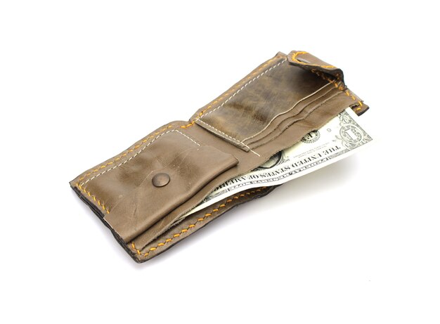 Portafoglio di cuoio marrone isolato con noi banconote dei soldi su fondo bianco