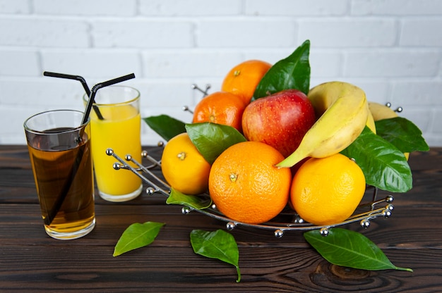 Portafrutta con frutta e due bicchieri di succo