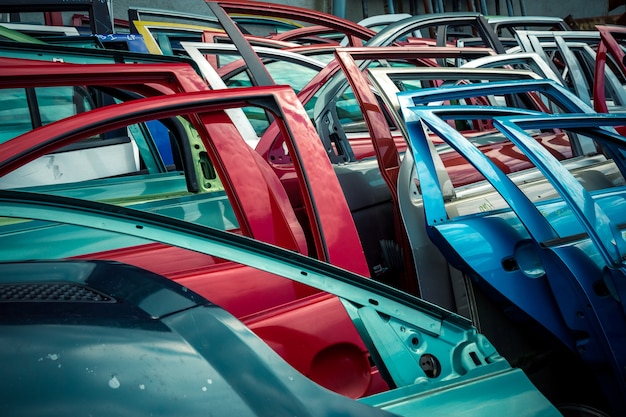 Porte di auto di diversi colori in una discarica