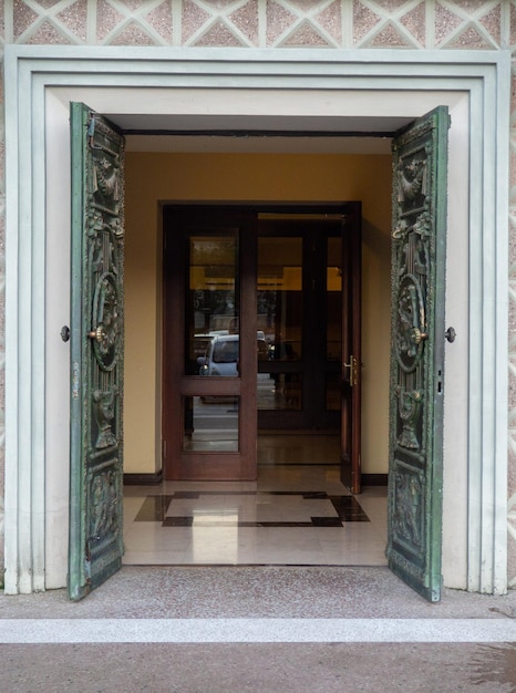 Porte pesanti in legno di un vecchio teatro Ingresso a un pomposo edificio Teatro georgiano Concetto di ingresso