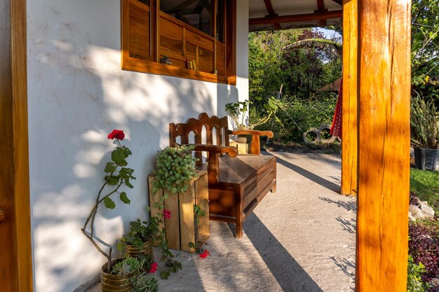 Portico antistante una casa di campagna con panca in legno in mezzo alla vegetazione