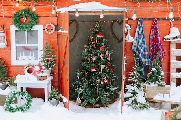 portico rosso del cortile della casa rurale decorato per Natale, natura morta invernale, vacanze di Capodanno