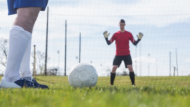 Portiere in rosso in attesa che l&#39;attaccante colpisca la palla