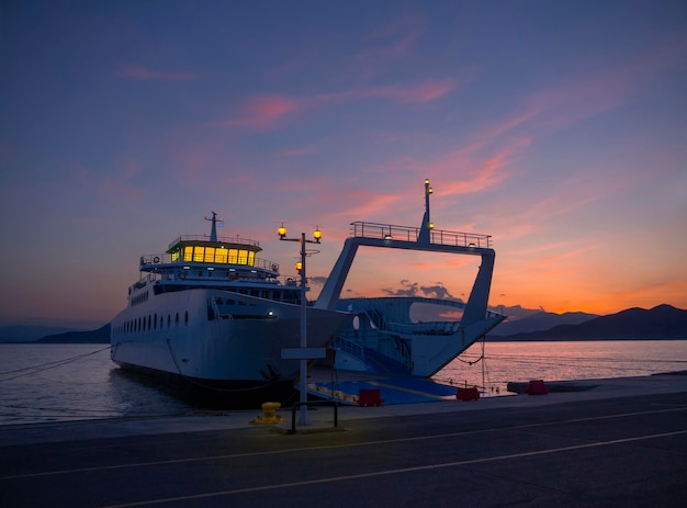 Porto con traghetto al tramonto in una località termale Loutra Edipsou sull'isola greca di Evia in Grecia