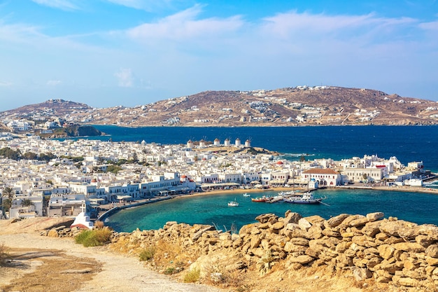 Porto della città di Mykonos con chiese rosse famosi mulini a vento navi e yacht durante la giornata di sole estivo Mar Egeo Grecia