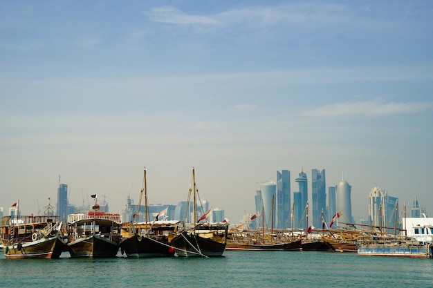 Porto di Doha con barche e skyline della città in lontananza