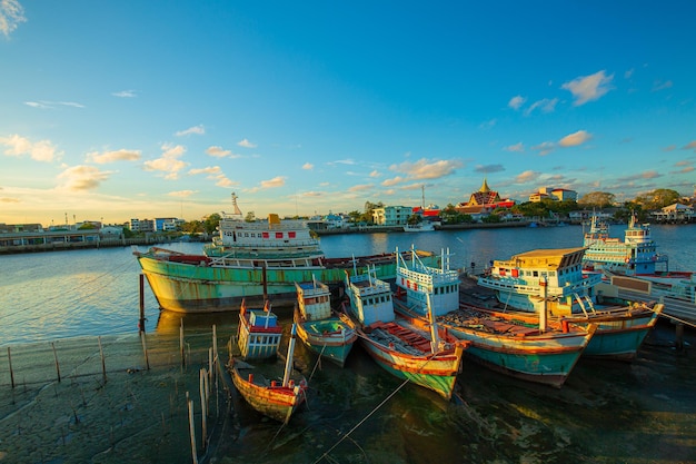 Porto di pesca e bel cielo in AsiaMolte barche ormeggiate all'alba al porto di Chalong Ma