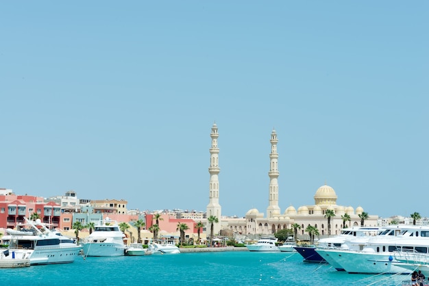 Porto marittimo con terrapieno in pietra con motoscafi parcheggiati e Moschea di Hurghada