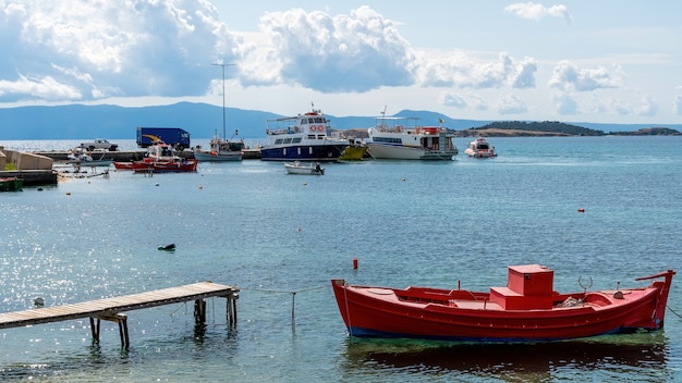 Porto marittimo, più barche ormeggiate sul Mar Egeo, poche auto su un molo a Ouranoupolis, Grecia