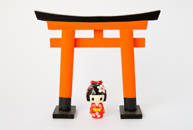 Portone di Torii con le bambole giapponesi su fondo bianco