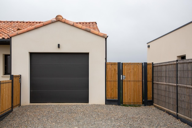 Portone sezionale basculante del garage nero e cancello d'ingresso di una nuova casa moderna