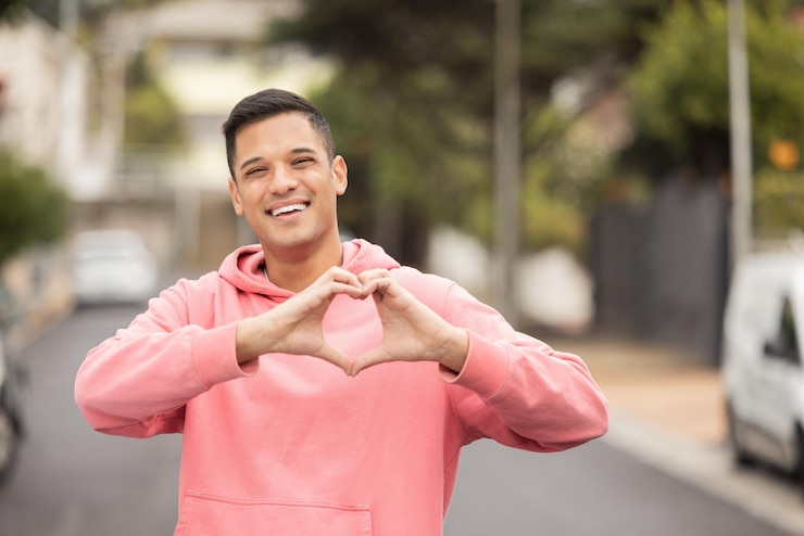 Photo portrait hands and heart by man in city happy and relax travel and journey on blurred background face traveler and emoji hands and shape by handsome guy showing icon love and smile for mexico