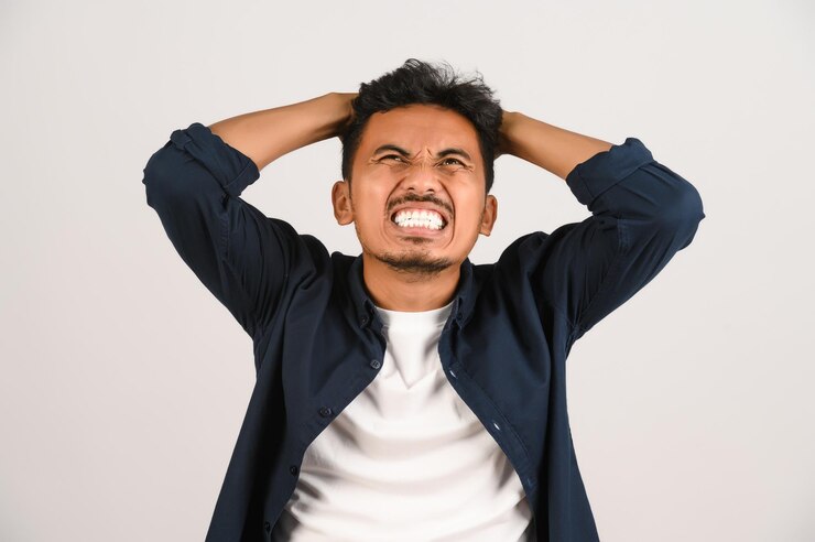 Portrait of Disappointed young asian man in blue shirt annoyed angry in furious gesture isolated on white background Expression and lifestyle concept