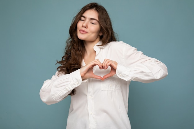 Portrait of young positive happy attractive curly brunette woman with sincere emotions wearing