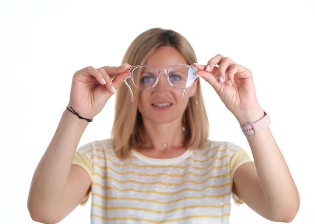 Portre giovane donna con problemi di vista tiene gli occhiali in mano