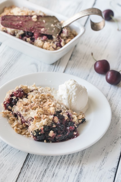 Porzione di crumble ai frutti di bosco con gelato alla vaniglia