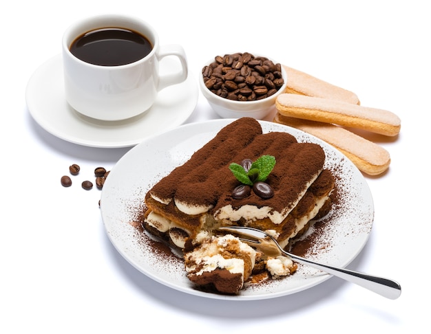 Porzione di dessert classico tiramisù e tazza di caffè espresso fresco isolato su priorità bassa bianca