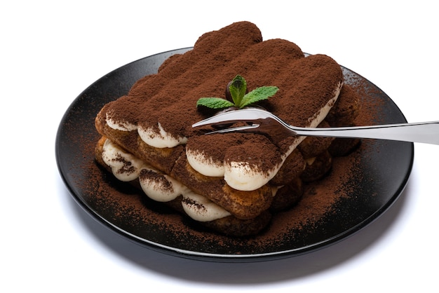 Porzione di dessert tiramisù classico sul piatto di ceramica isolato su priorità bassa bianca