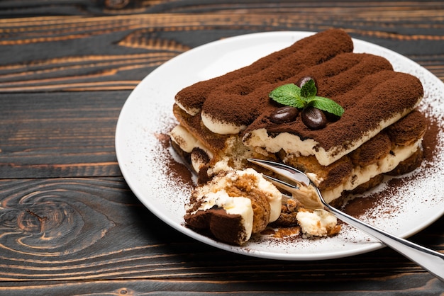 Porzione di dolce tiramisù classico su un piatto di ceramica