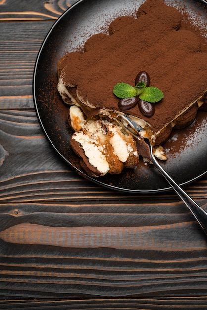 Porzione di dolce tiramisù classico su un piatto di ceramica