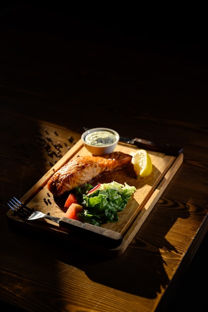 Porzione di filetto di salmone con erbe su un tavolo di legno. Vista dall'alto