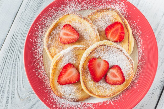 Porzione di frittelle di ricotta con fragole fresche