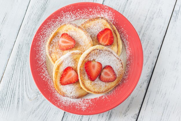 Porzione di frittelle di ricotta con fragole fresche