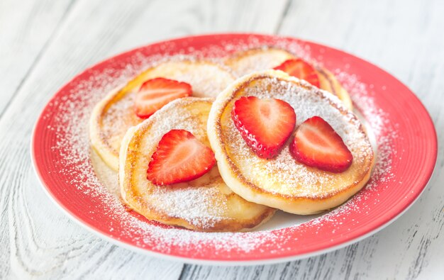 Porzione di frittelle di ricotta con fragole fresche