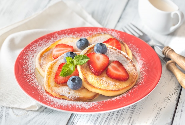 Porzione di frittelle di ricotta con frutti di bosco freschi