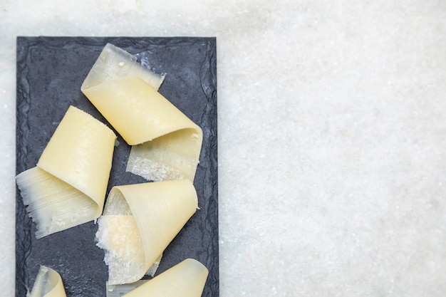 Porzione di parmigiano in scaglie con aceto balsamico in pietra nera