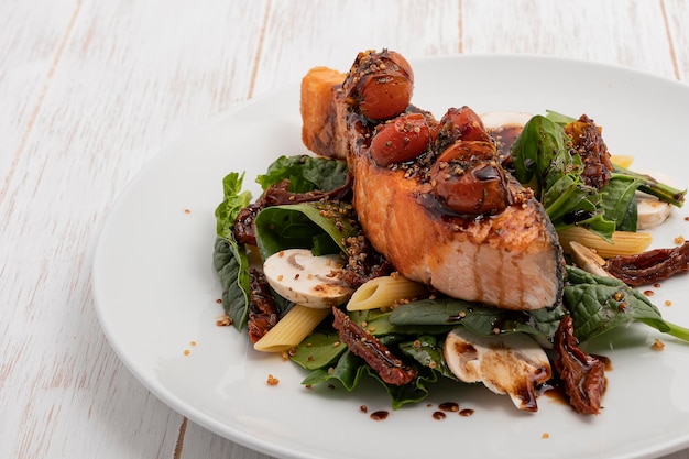 Porzione di salmone con sopra pomodorini e verdure