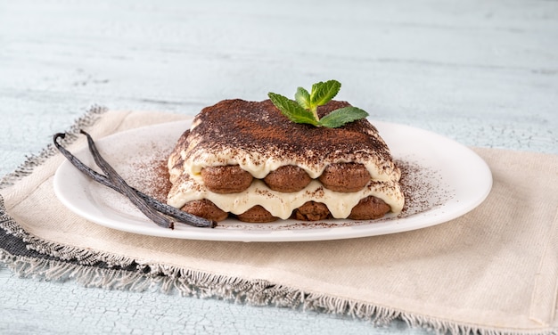 Porzione di tiramisù sul piatto da portata bianco