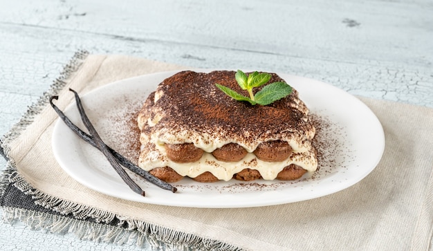 Porzione di tiramisù sul piatto da portata bianco