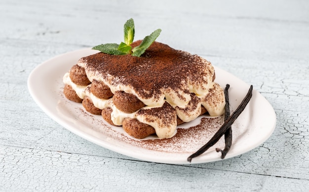 Porzione di tiramisù sul piatto da portata bianco