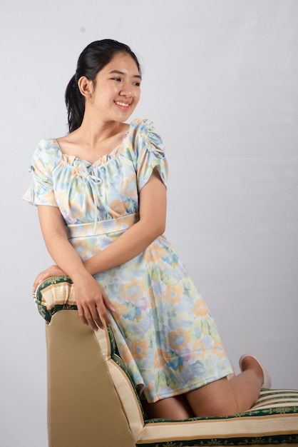 Posa asiatica della giovane donna con il tiro dello studio del vestito da estate