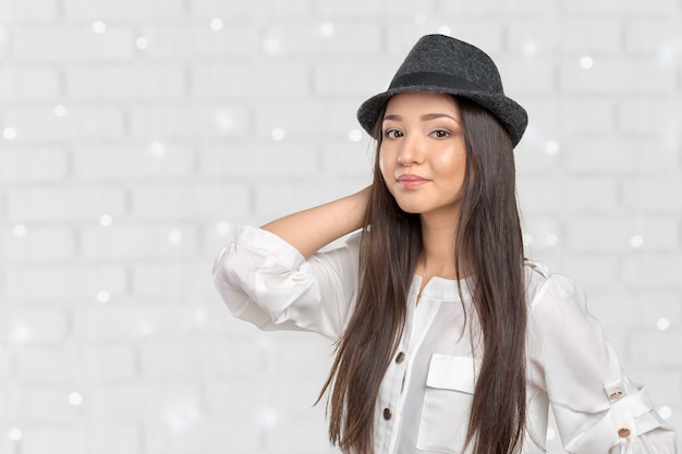 Posa d'uso del cappello di paglia della fedora di estate della bella giovane donna