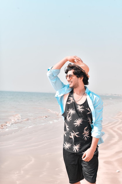 posa frontale casual giovane con sorridente in spiaggia modello pakistano indiano