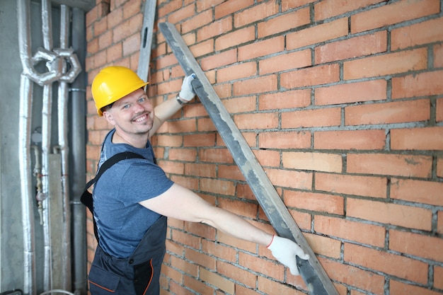 Posa maschio sorridente nella stanza non finita