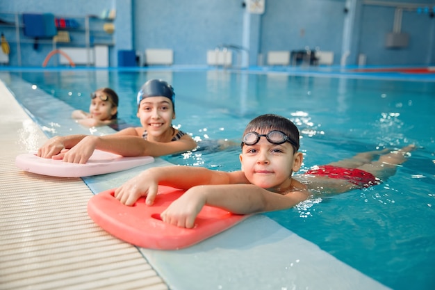 Pose di gruppo di nuoto di bambini a bordo piscina