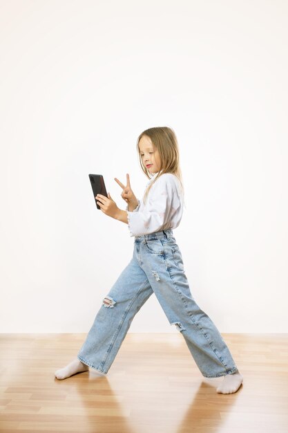 Positiva bambina blogger popolare fa selfie smartphone mostra vsign indossare abiti eleganti