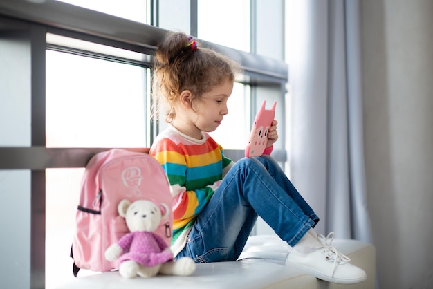 Positivo bambina che tiene il computer tablet nelle sue mani I bambini usano la tecnologia