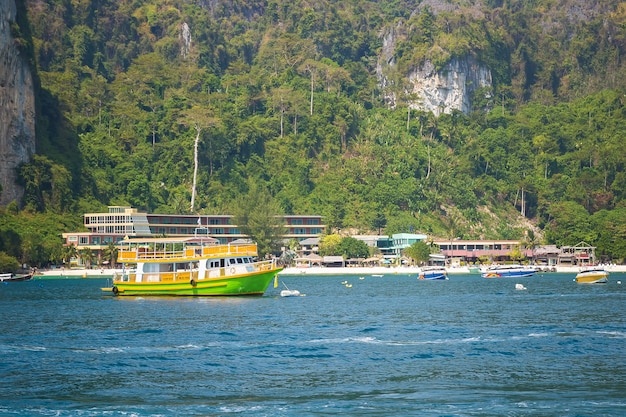 Positivo colorato in verde e giallo in motoscafo turistico per passeggeri in crociera vicino alla spiaggia di Railay