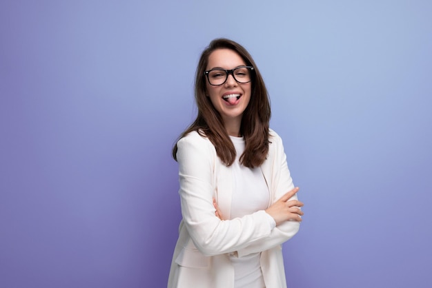 Positivo giovane donna bruna d'affari in abito da ufficio bianco su sfondo blu studio