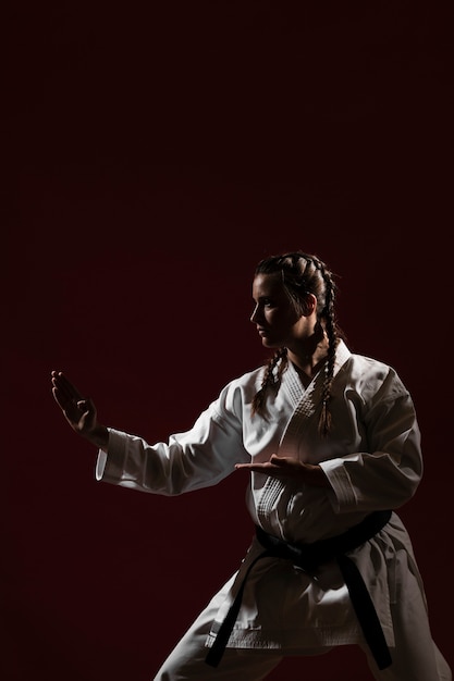 Posizione di combattimento della donna in uniforme bianca di karate