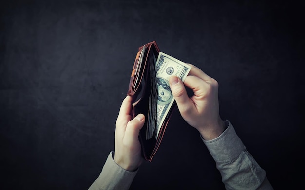 Posizione finanziaria Mani in possesso di banconote in contanti in una borsa su sfondo grigio Valuta