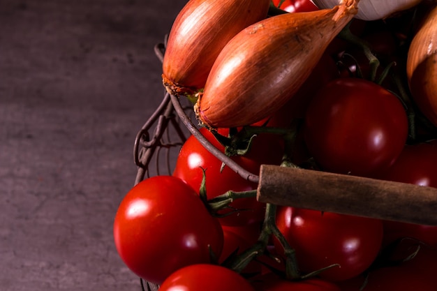 Poster di un vecchio cestino con pomodori aglio cipolla per decorare la cucina